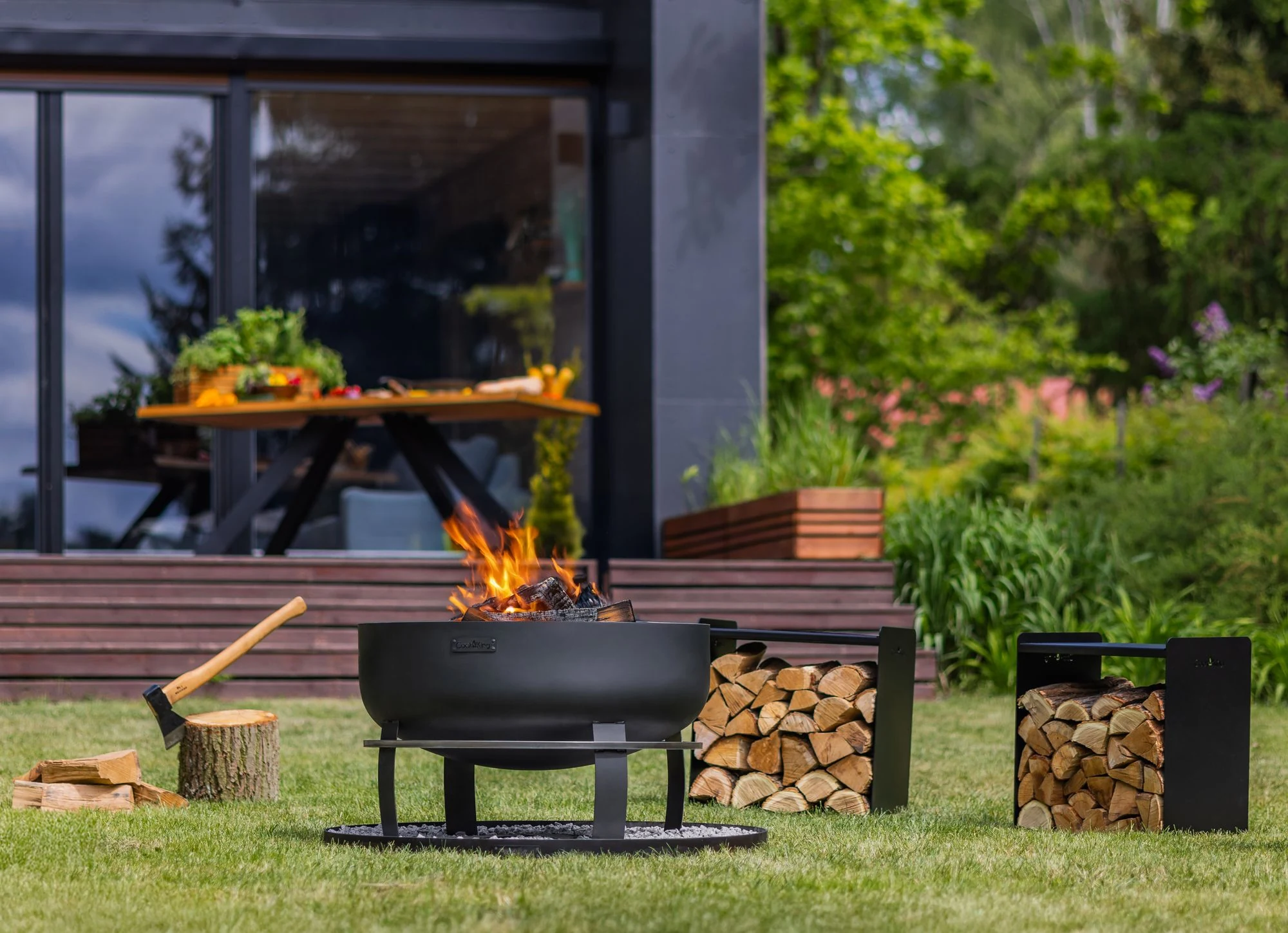 COOK KING fire bowl in a garden with tools for firewood
